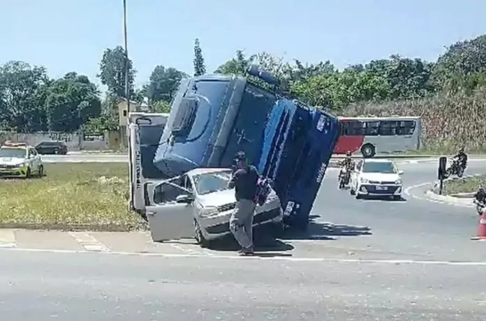 BR-040: vídeo mostra carreta tombando em cima de carro parado na rotatória