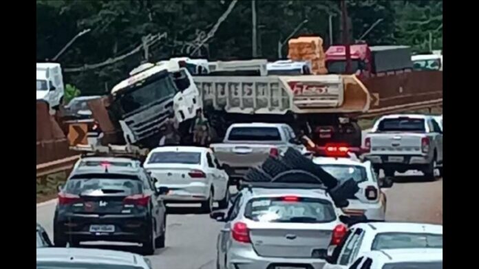 Carreta atinge mureta, fica em formato de 