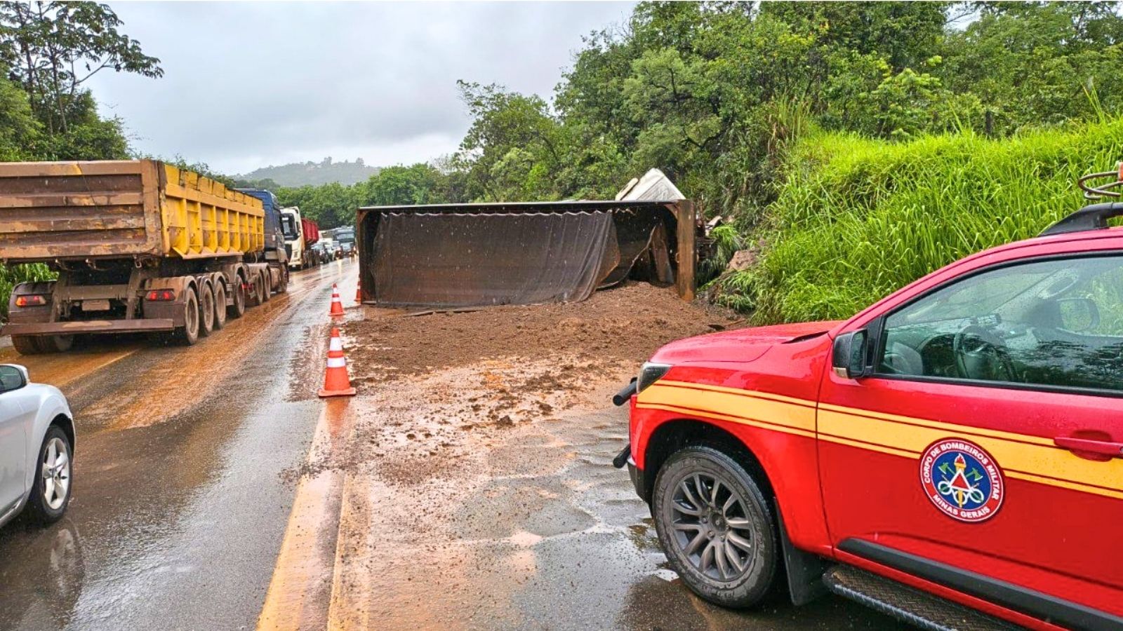 Motorista fica ferido após carreta carregada com terra tombar na BR-381 Motorista fica ferido após carreta carregada com terra tombar na BR-381